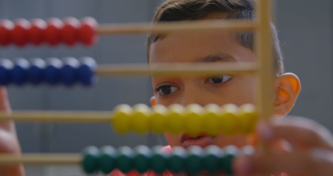 Child Concentrating on Abacus in Classroom