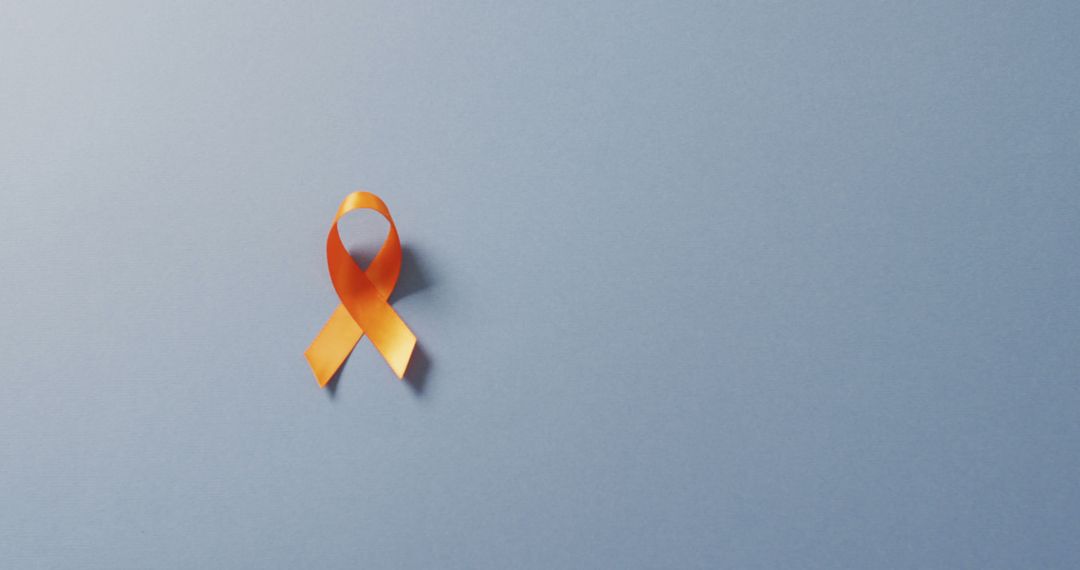Image of orange kidney cancer or leukemia ribbon on pale blue background - Free Images, Stock Photos and Pictures on Pikwizard.com