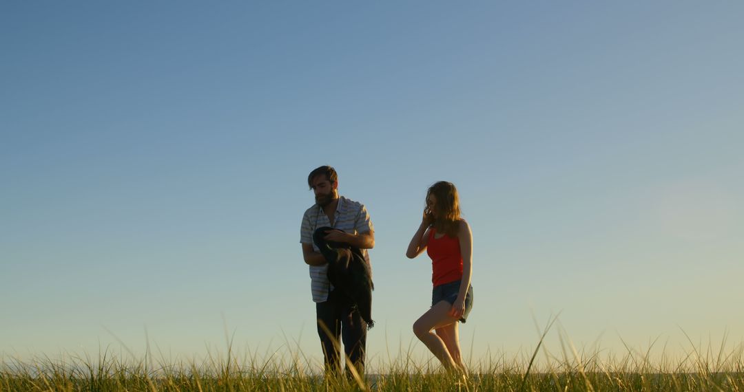 Couple Walking in Meadow Early Evening in Summer - Free Images, Stock Photos and Pictures on Pikwizard.com