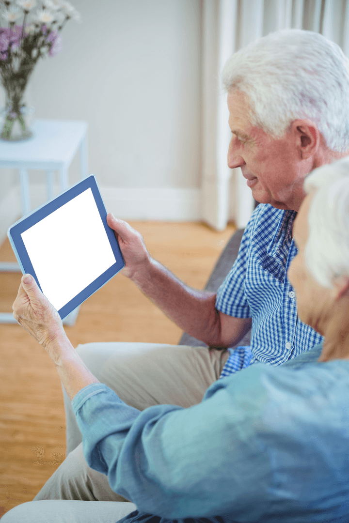 Senior Couple Engaging with Transparent Digital Tablet at Home