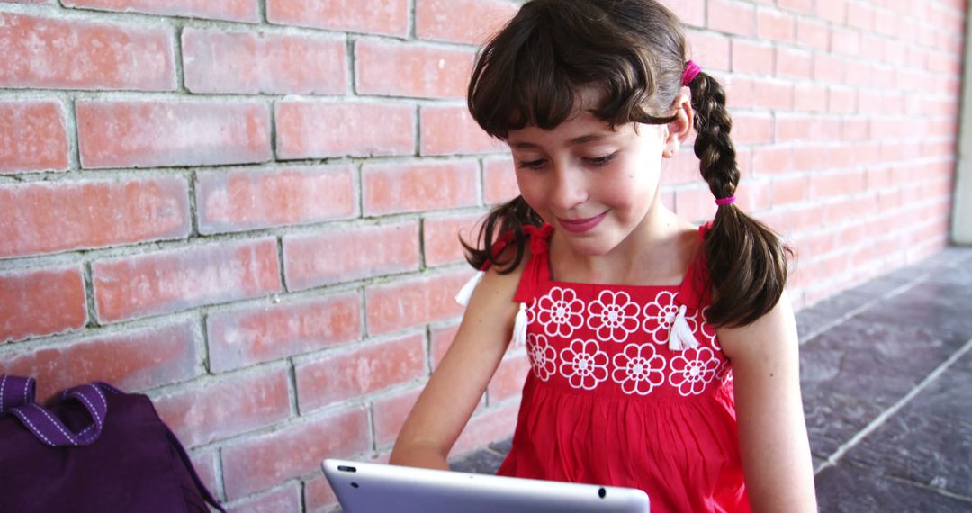 Schoolgirl Engaged with Digital Tablet in Hallway - Free Images, Stock Photos and Pictures on Pikwizard.com