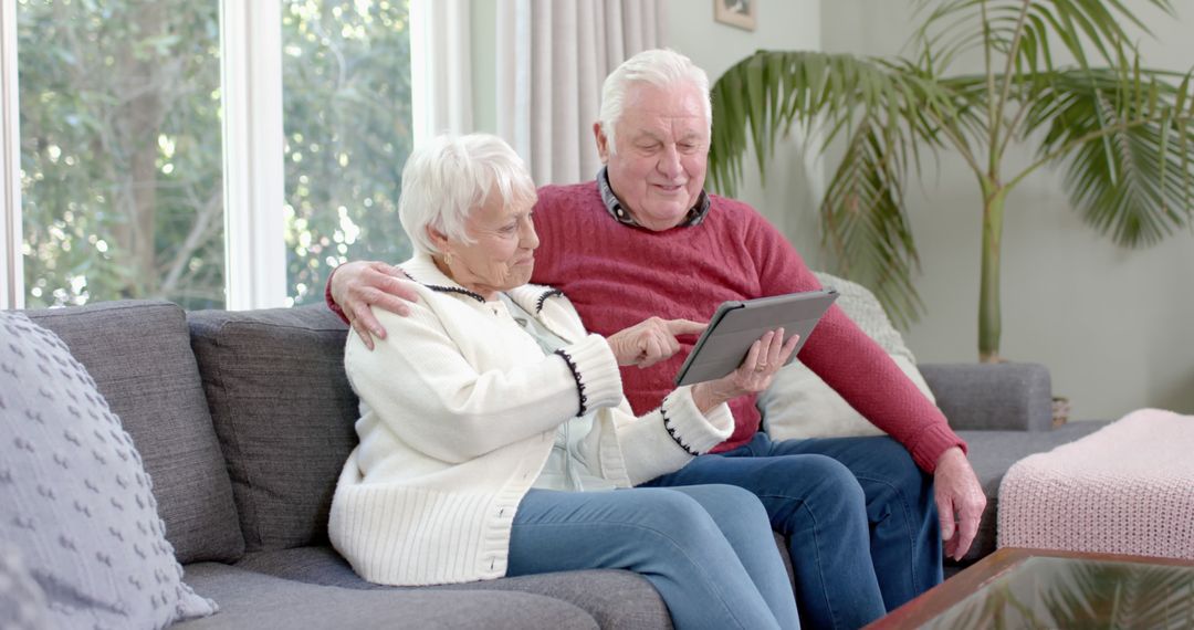 Senior Couple Embracing Technology on Sofa at Home