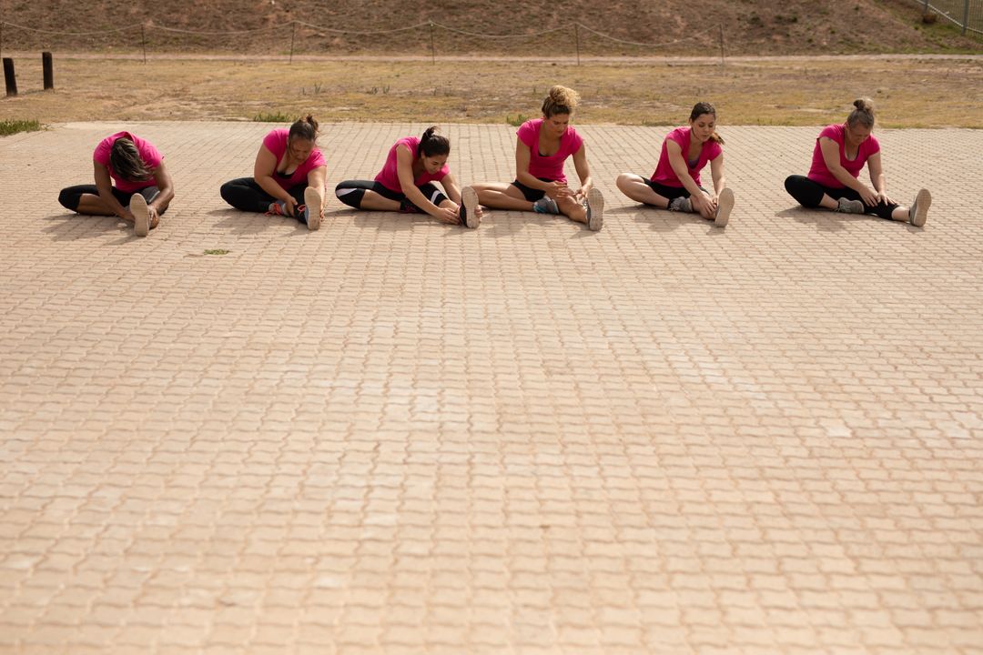 Women in Pink Shirts Stretching at Outdoor Boot Camp - Free Images, Stock Photos and Pictures on Pikwizard.com