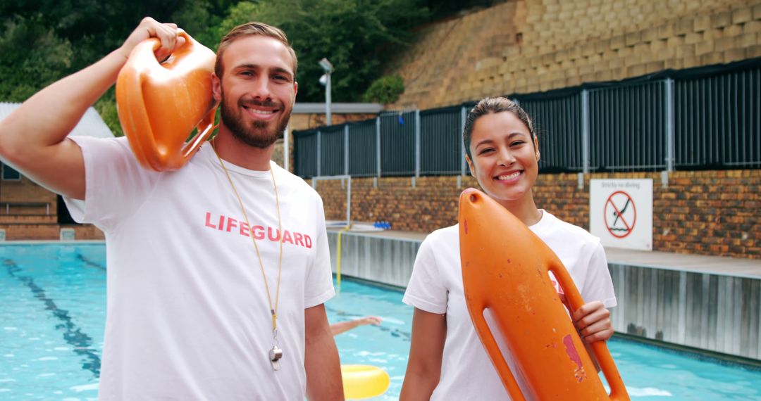 Smiling Lifeguards Standing by Swimming Pool with Rescue Buoys - Free Images, Stock Photos and Pictures on Pikwizard.com