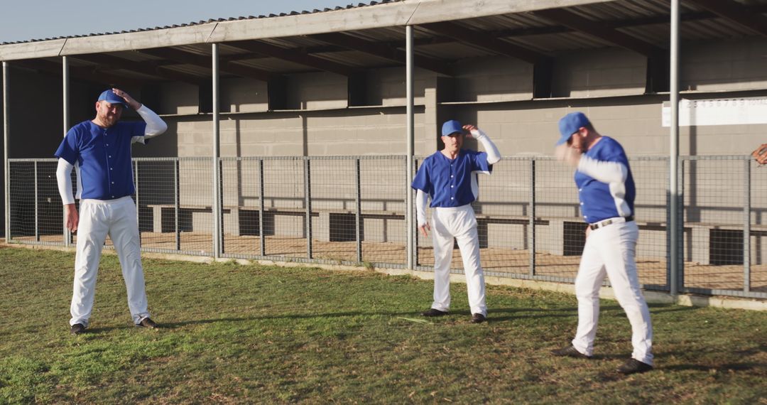 Three Male Baseball Players Adjusting Caps on Field During Warmup