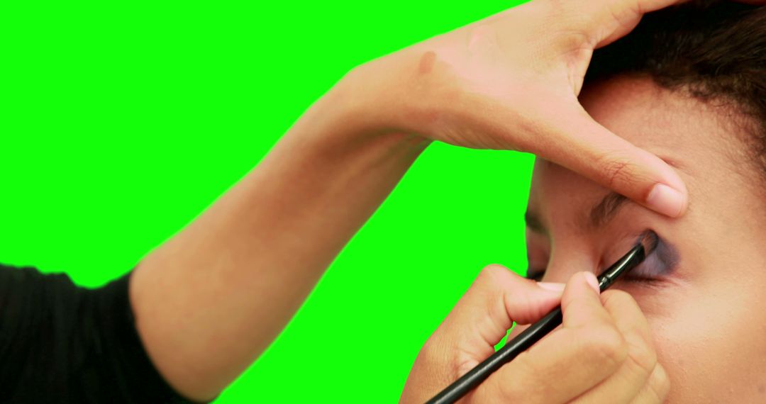 Makeup Artist Applying Eyeshadow on Model Against Green Screen
