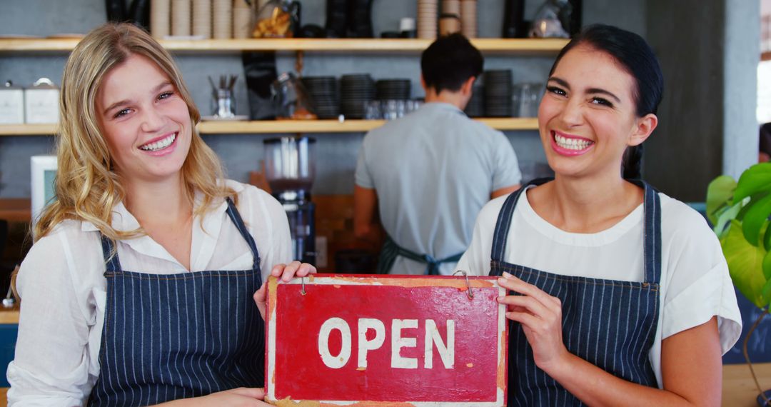 Smiling Waitstaff Holding Open Sign in Cafe