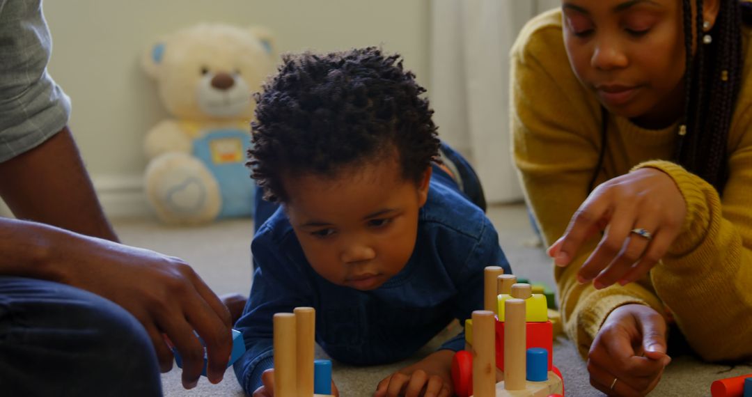 Parents Playing with Toddler Using Learning Toys Indoors