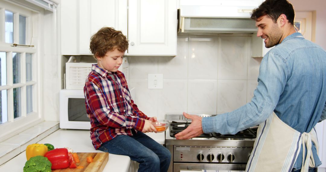 Father and son bonding while cooking in modern kitchen - Free Images, Stock Photos and Pictures on Pikwizard.com