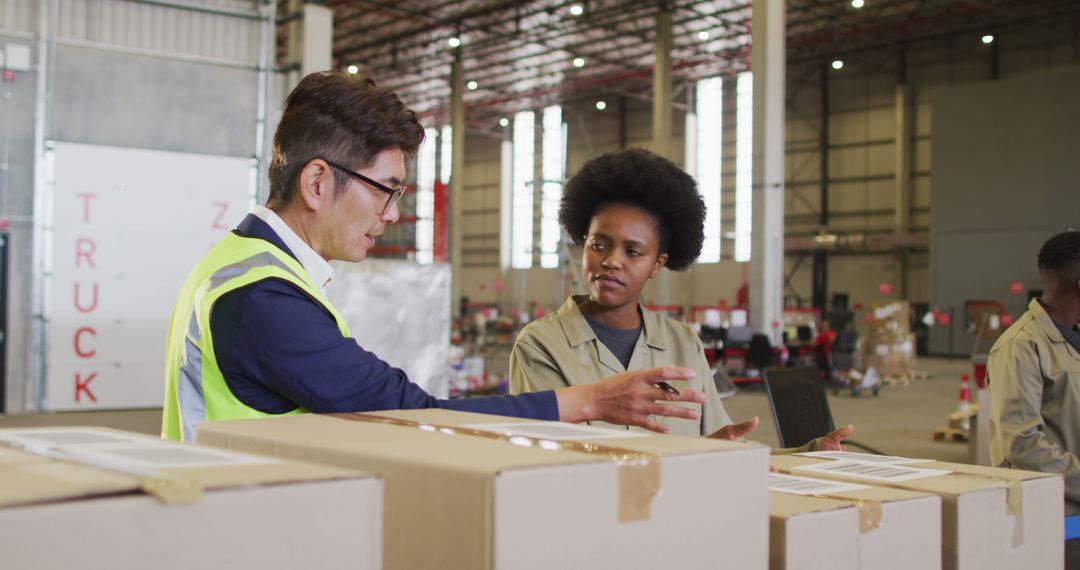 Warehouse Team Discussing Logistics Amongst Shipment Boxes