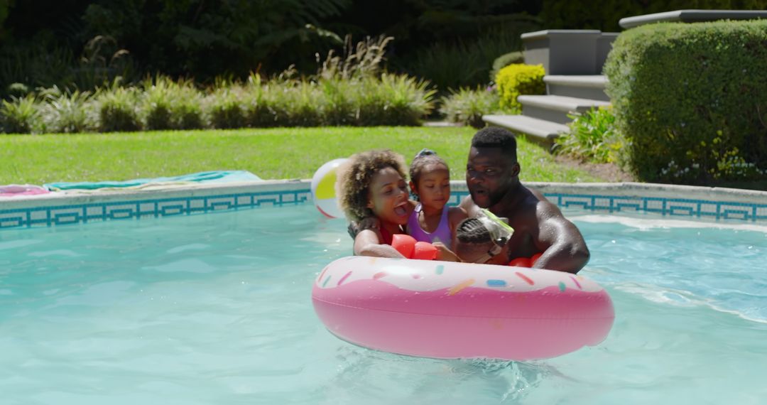 Happy Family Floating in Pink Inflatable Ring at Backyard Pool