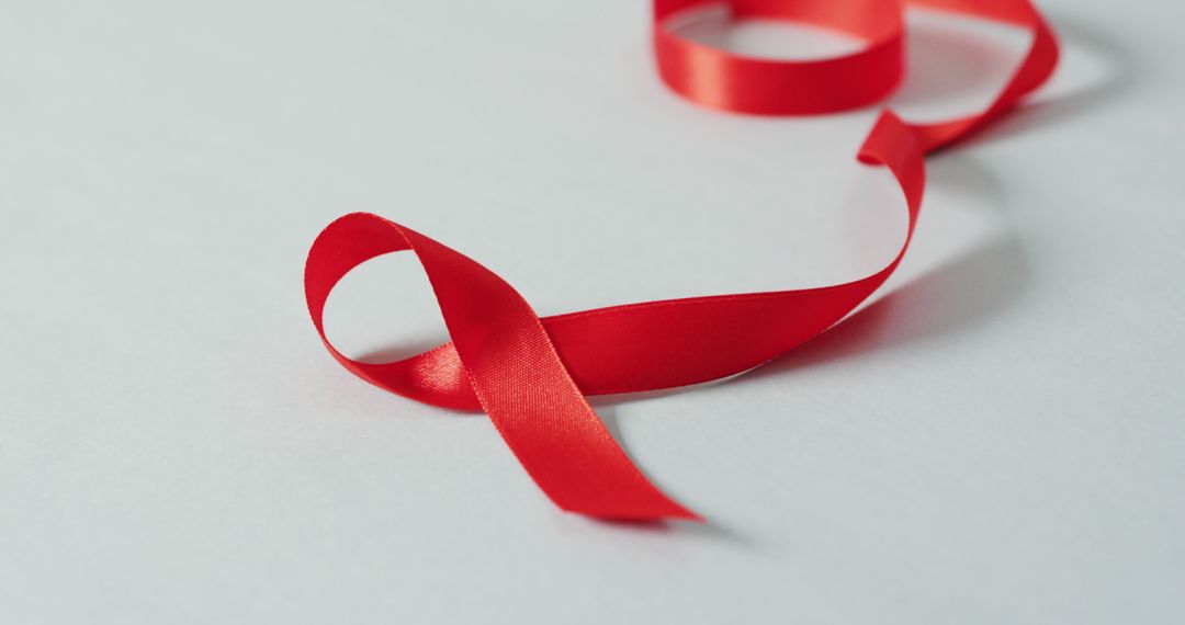 Close-Up of Red Ribbon Loop on White Background - Free Images, Stock Photos and Pictures on Pikwizard.com