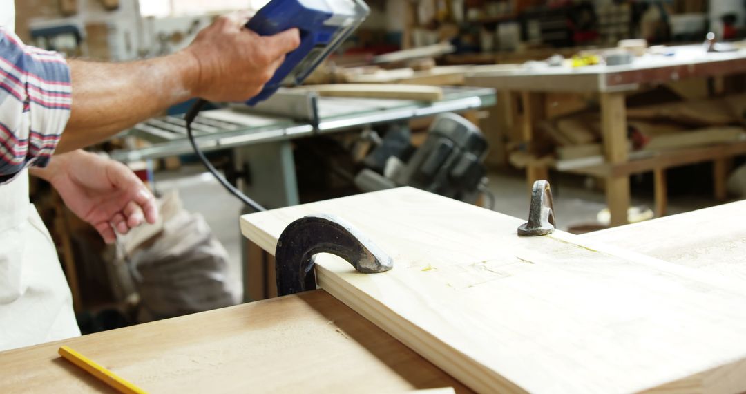 Carpenter Using Power Tool on Wooden Plank in Workshop - Free Images, Stock Photos and Pictures on Pikwizard.com