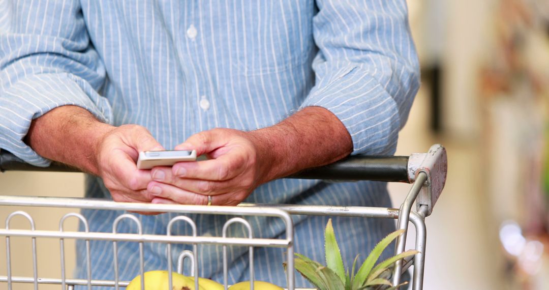 Male Shopper Using Smartphone in Supermarket - Free Images, Stock Photos and Pictures on Pikwizard.com