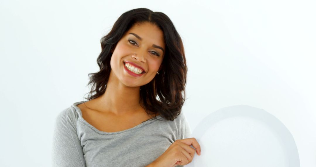 Smiling Woman Holding Blank White Circle Against Light Background - Free Images, Stock Photos and Pictures on Pikwizard.com