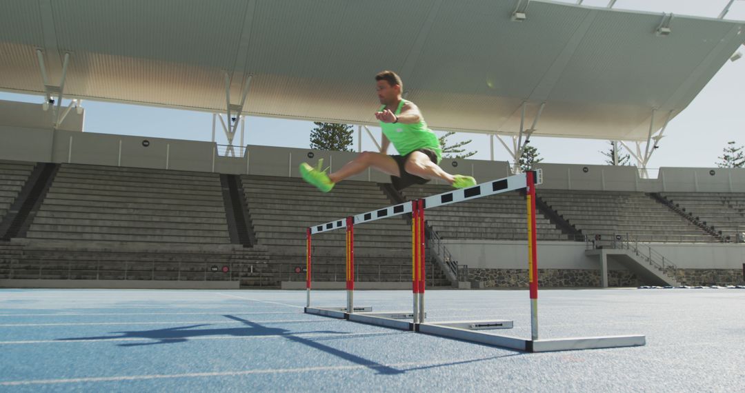 Athlete Jumping Over Hurdles on Track - Free Images, Stock Photos and Pictures on Pikwizard.com