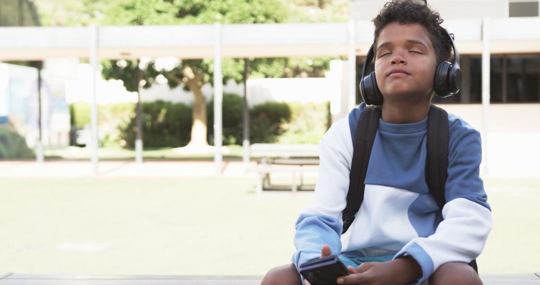 Relaxed Student Enjoying Music in School Courtyard