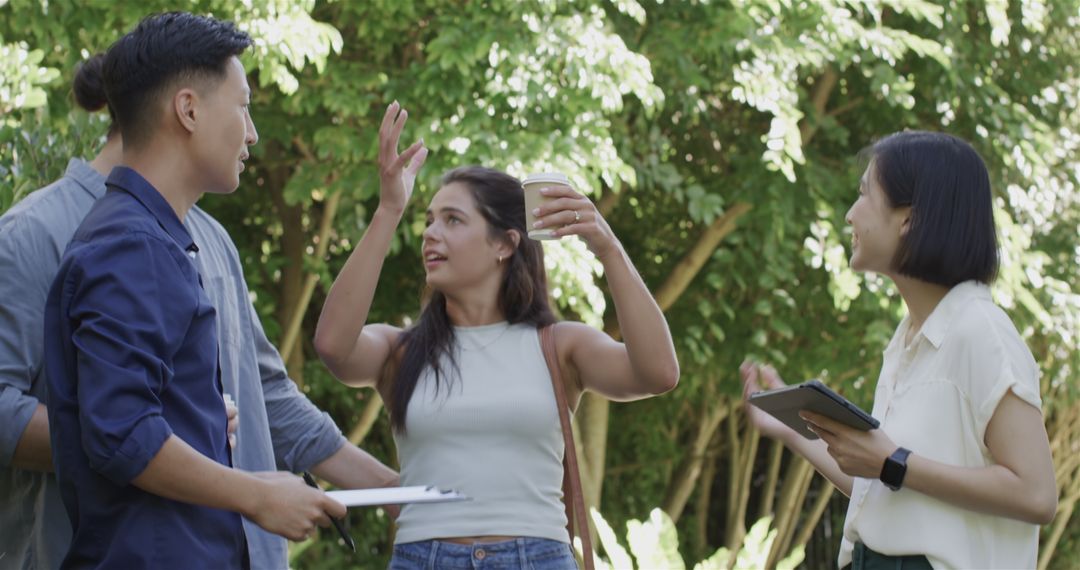 Group Discussing Wedding Plans Outdoors with Tablet and Clipboard