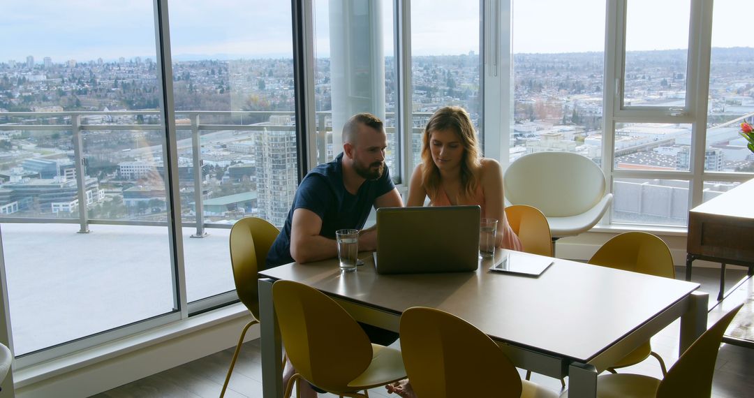 Couple Working Together on Laptop in Modern Apartment with City View - Free Images, Stock Photos and Pictures on Pikwizard.com