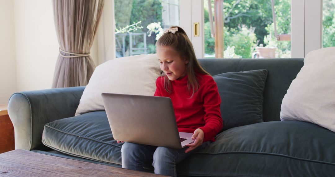 Young Girl Enjoying Laptop at Home on Couch - Free Images, Stock Photos and Pictures on Pikwizard.com