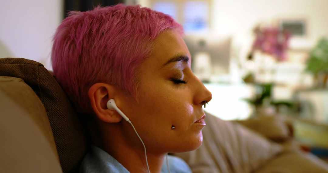 Young Woman Relaxing with Earbuds and Pink Hair - Free Images, Stock Photos and Pictures on Pikwizard.com