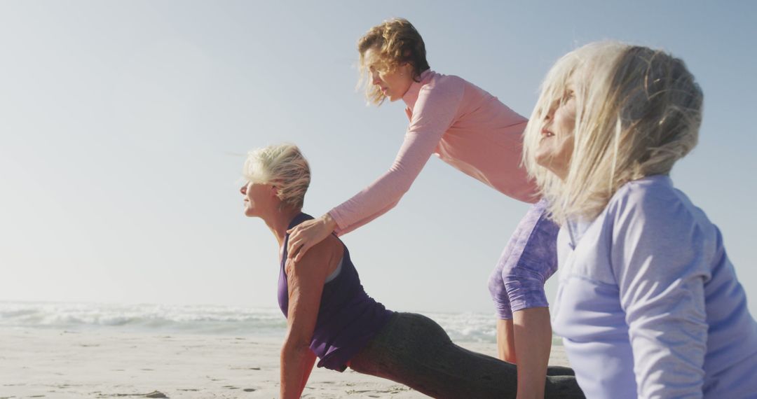 Women Practicing Yoga with Instructor on Sunny Beach - Free Images, Stock Photos and Pictures on Pikwizard.com