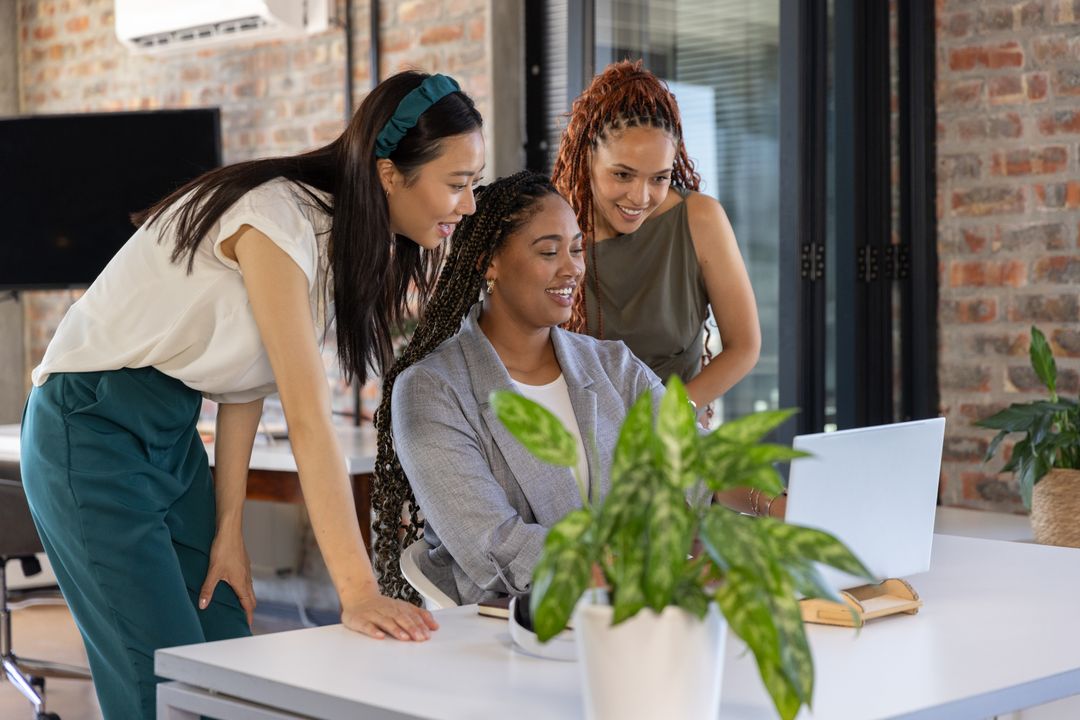 Diverse Female Team Collaborating in Modern Office with Laptop