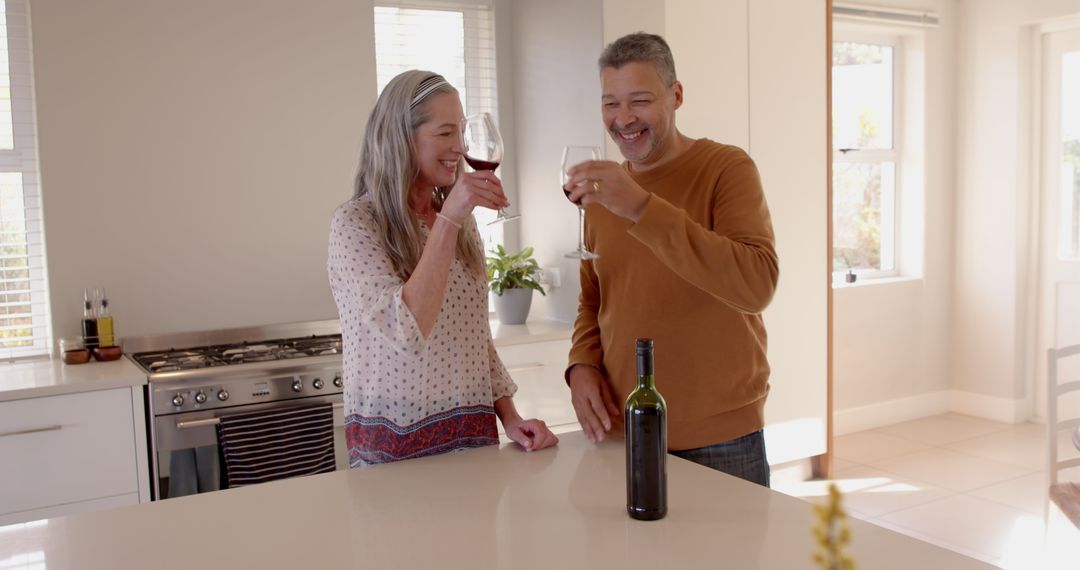 Senior Couple Enjoying Wine Tasting in Modern Kitchen
