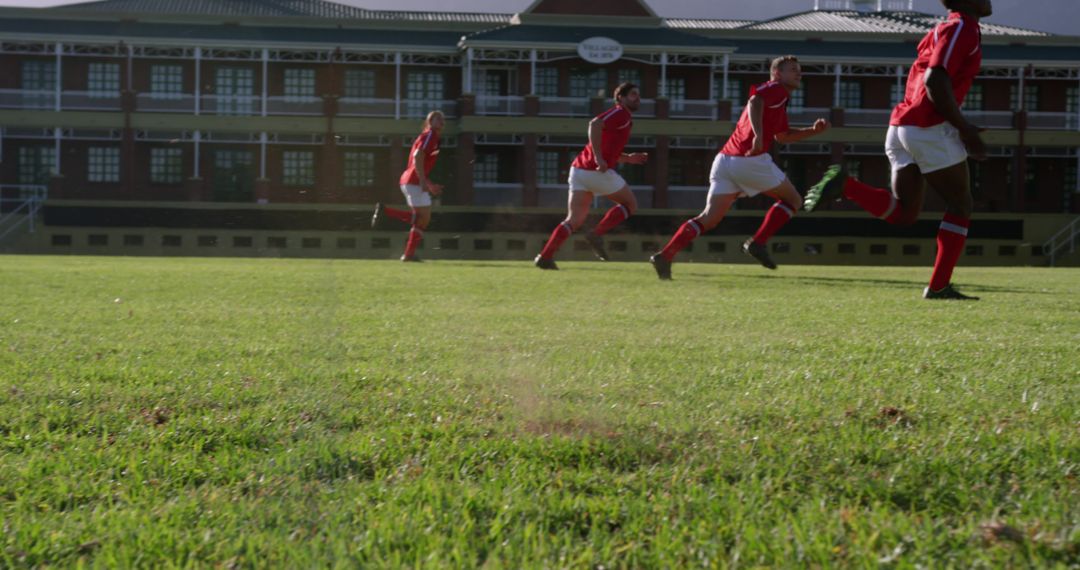 Soccer Players in Red Running Towards Goal on Green Field - Free Images, Stock Photos and Pictures on Pikwizard.com