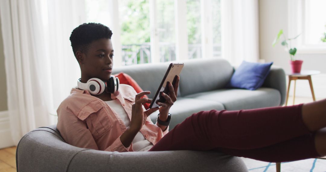 Young African American Woman Relaxing with Tablet and Headphones - Free Images, Stock Photos and Pictures on Pikwizard.com