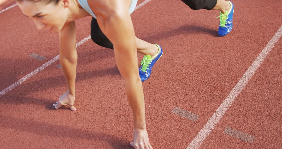 Female Athlete in Starting Position for Sprint Race on Track