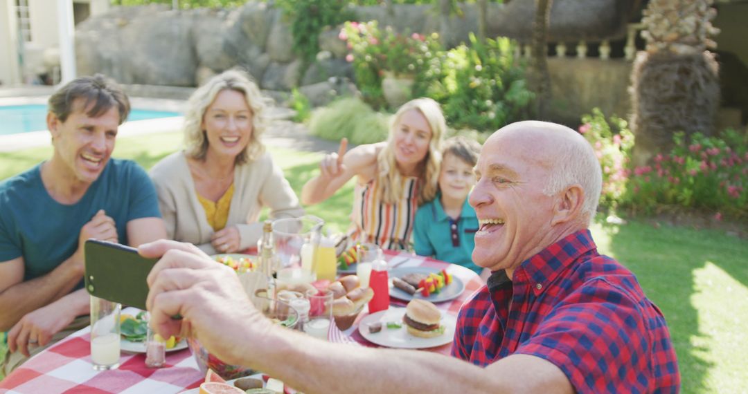 Grandfather Taking Selfie with Smiling Multi-generational Family Outdoors