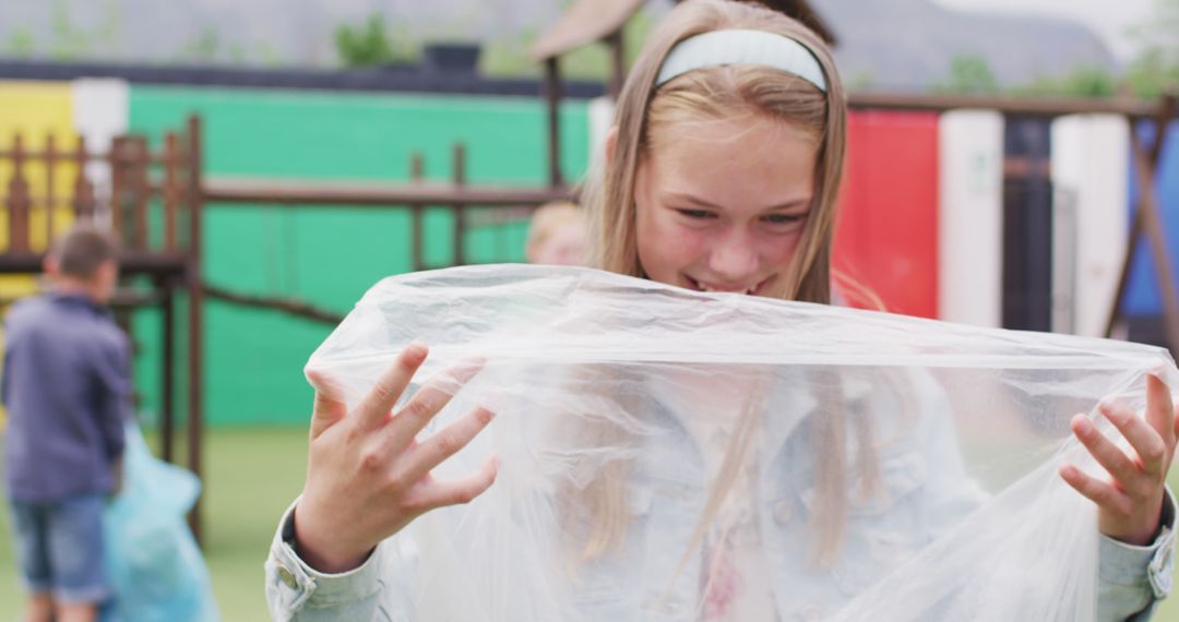 Girl Enjoying Playtime with Plastic Sheet Outdoors - Free Images, Stock Photos and Pictures on Pikwizard.com