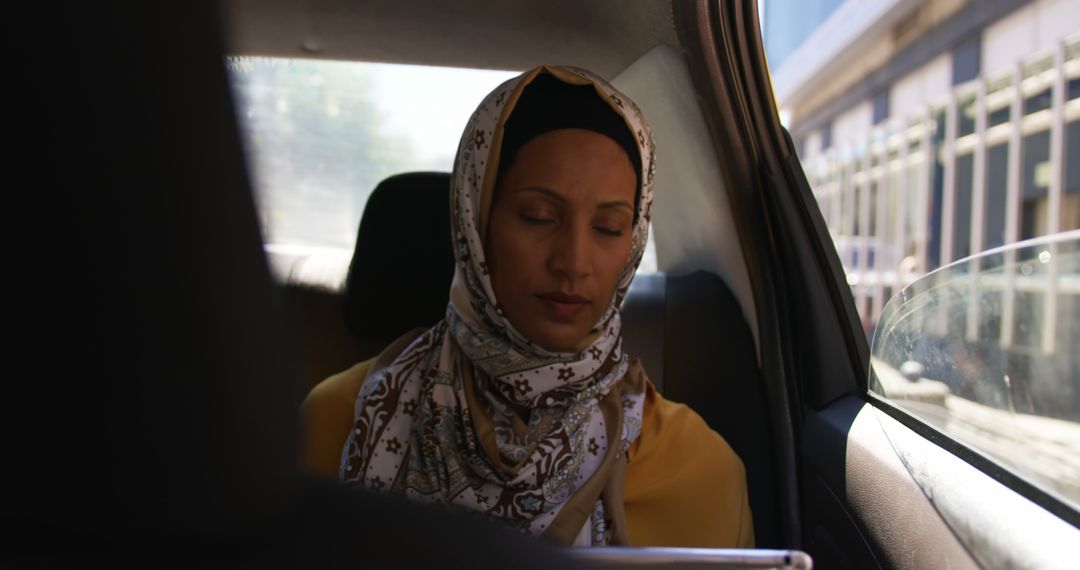 Businesswoman Wearing Headscarf Using Tablet in Car - Free Images, Stock Photos and Pictures on Pikwizard.com