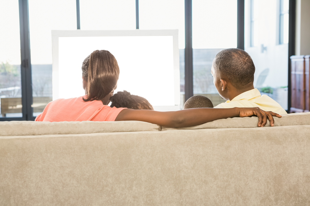 Rear view of family watching TV together with transparent screen - Download Free Stock Images Pikwizard.com