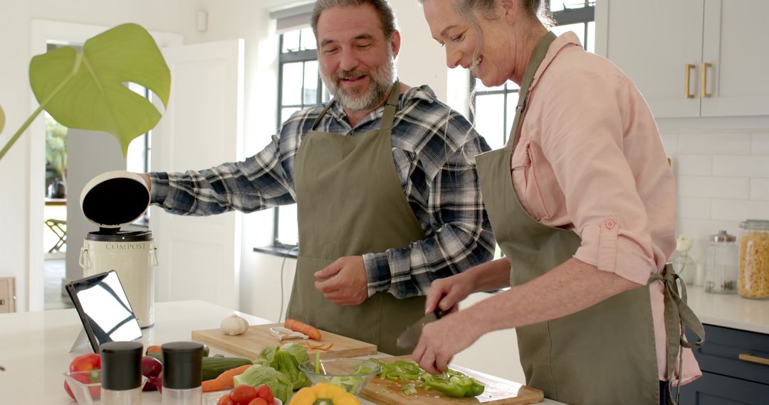 Senior Couple Cooking Together in Modern Kitchen with Tablet