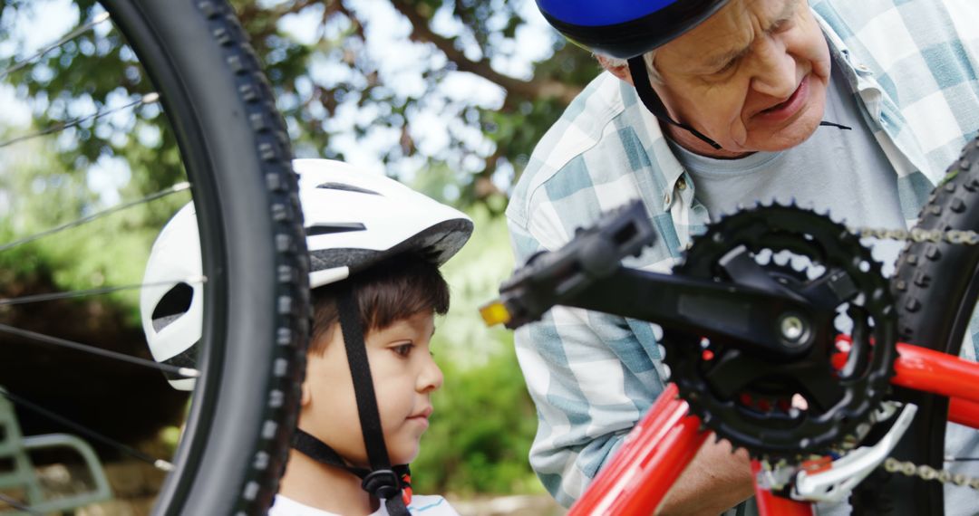 Grandfather and Grandson Repairing Bicycle Outdoors - Free Images, Stock Photos and Pictures on Pikwizard.com