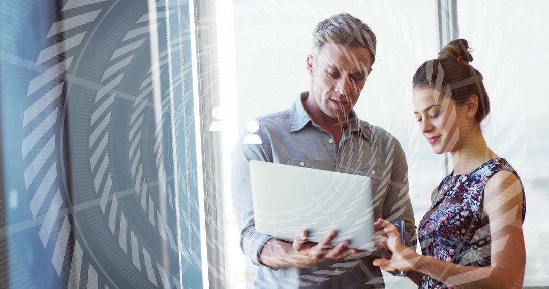Colleagues Analyzing Data on Laptop with High-Tech Interface