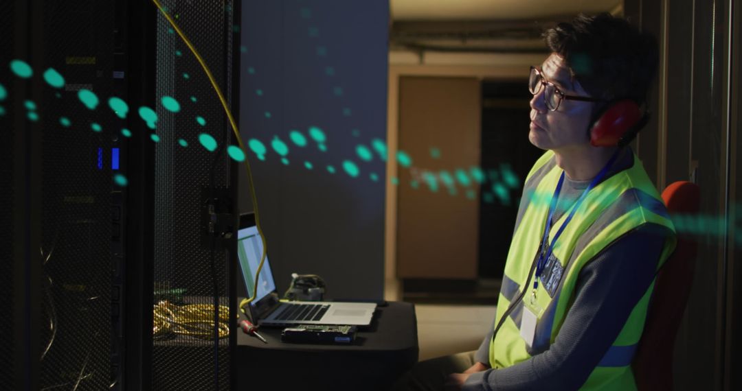 Technician Analyzing Data at Night in Server Room