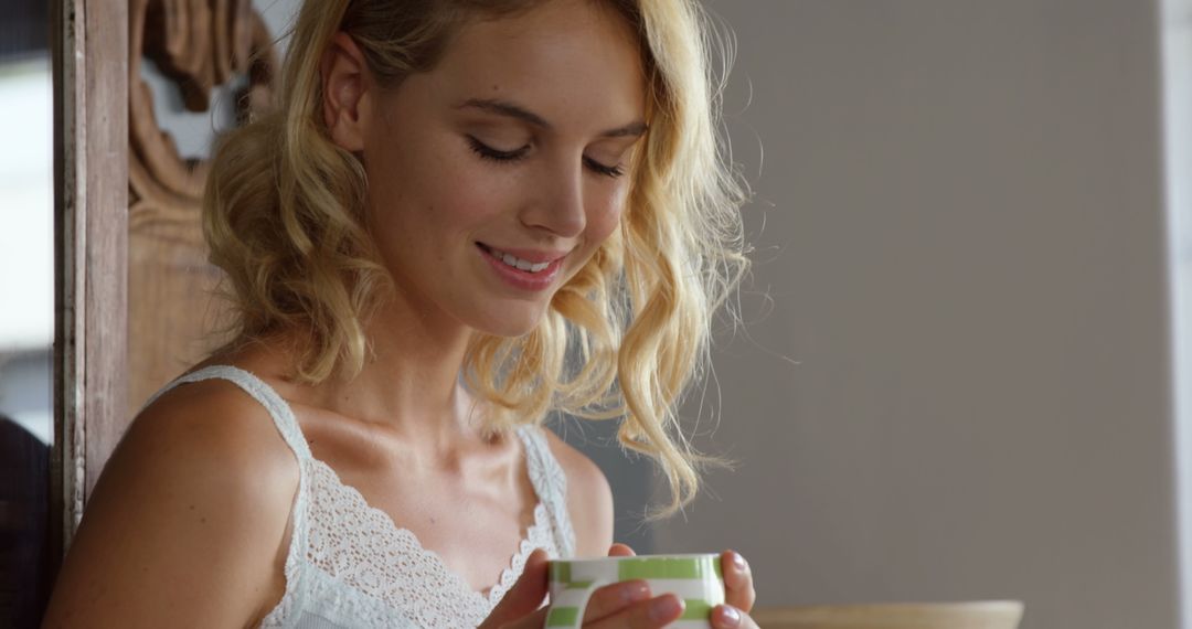 Smiling Woman Enjoying a Cup of Tea in Bright Room - Free Images, Stock Photos and Pictures on Pikwizard.com