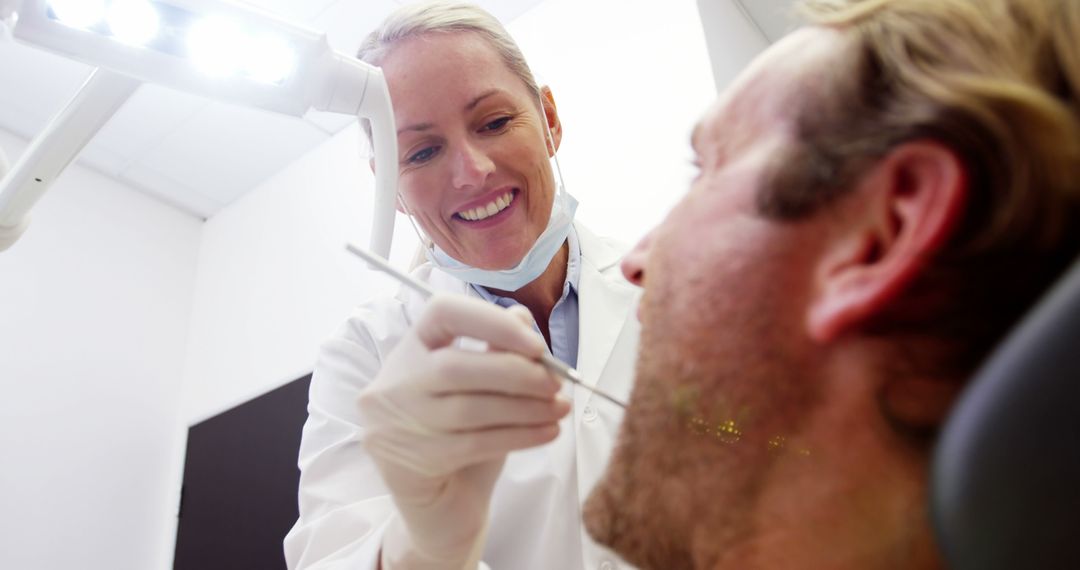 Friendly Dentist Examining Patient in Modern Clinic - Free Images, Stock Photos and Pictures on Pikwizard.com