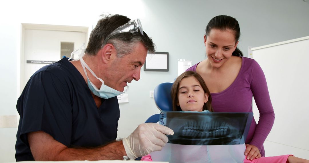 Dentist Showing Child and Mother X-Ray in Examination Room - Free Images, Stock Photos and Pictures on Pikwizard.com