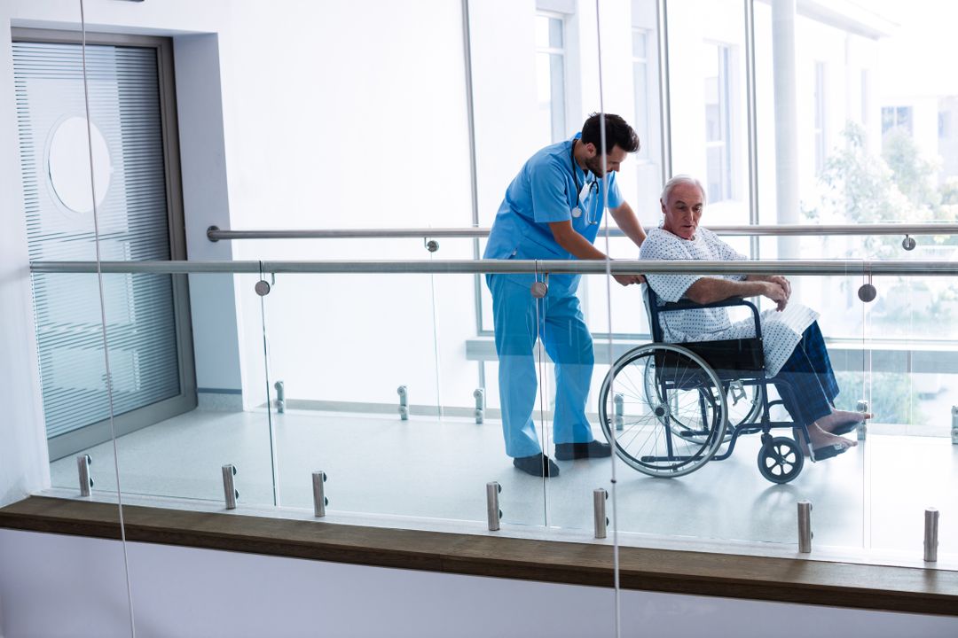 Doctor Pushing Senior Patient in Wheelchair in Hospital Corridor - Free Images, Stock Photos and Pictures on Pikwizard.com