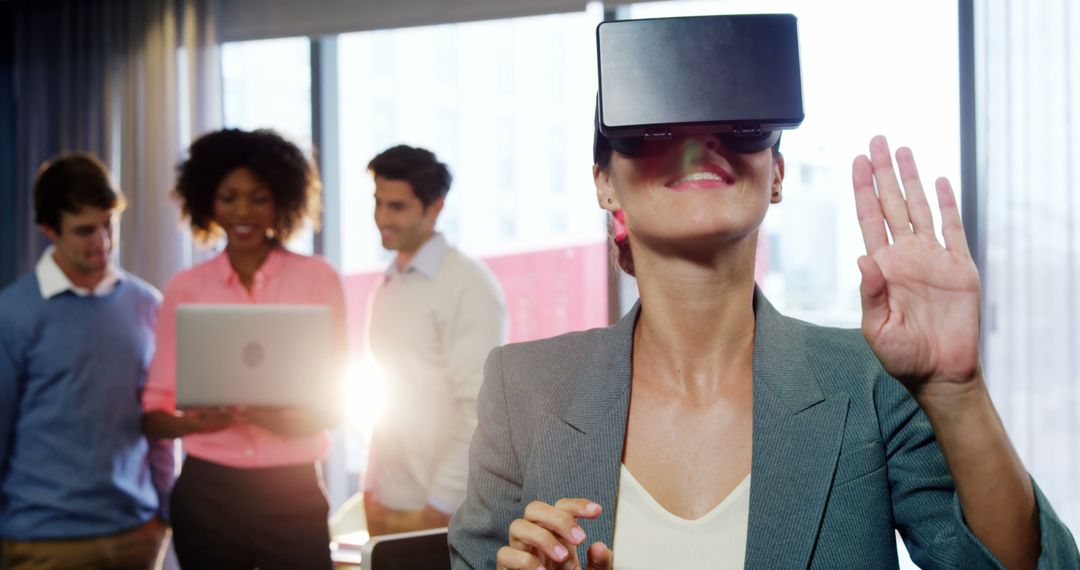 Businesswoman Using VR Headset in Modern Office with Colleagues - Free Images, Stock Photos and Pictures on Pikwizard.com