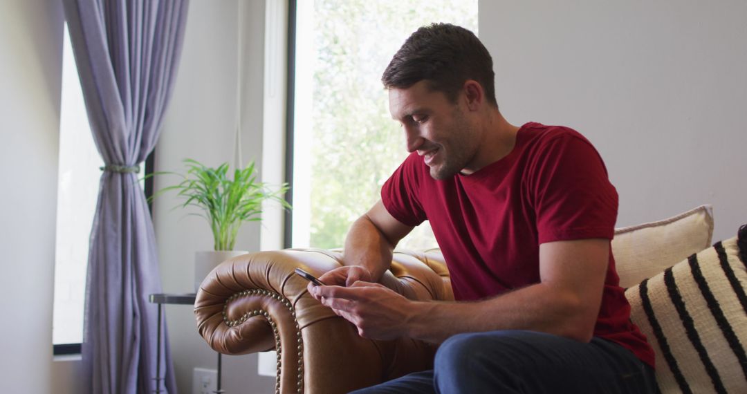 Caucasian Man Relaxing with Smartphone at Home