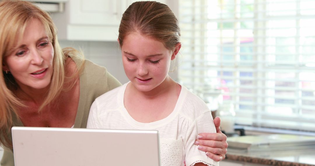 Mother Helping Daughter with Homework on Laptop at Kitchen Table - Free Images, Stock Photos and Pictures on Pikwizard.com