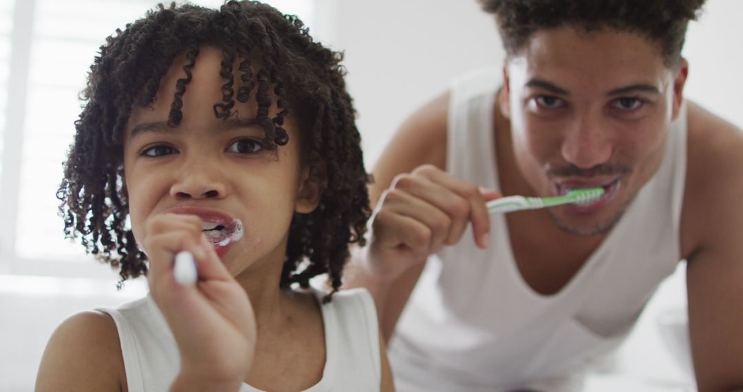 Happy biracial man and his son washing teeth in bathroom - Free Images, Stock Photos and Pictures on Pikwizard.com