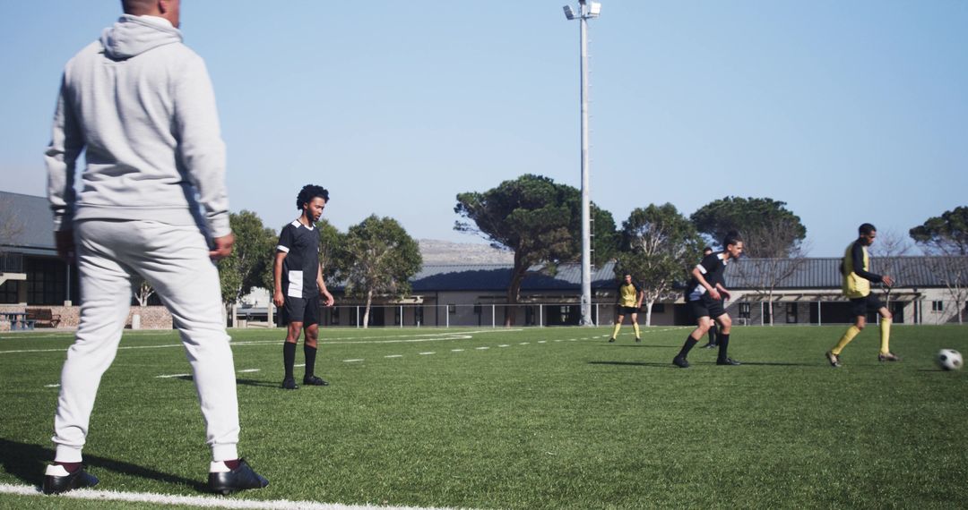 Soccer Coach Observing Practice on Green Field