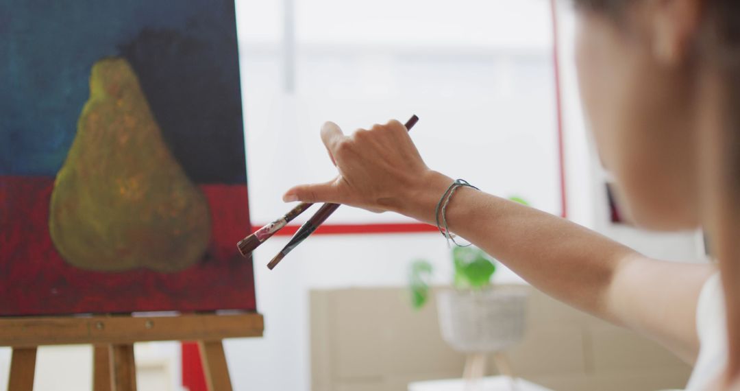 Artist Adding Final Touches to Still Life Painting in Studio