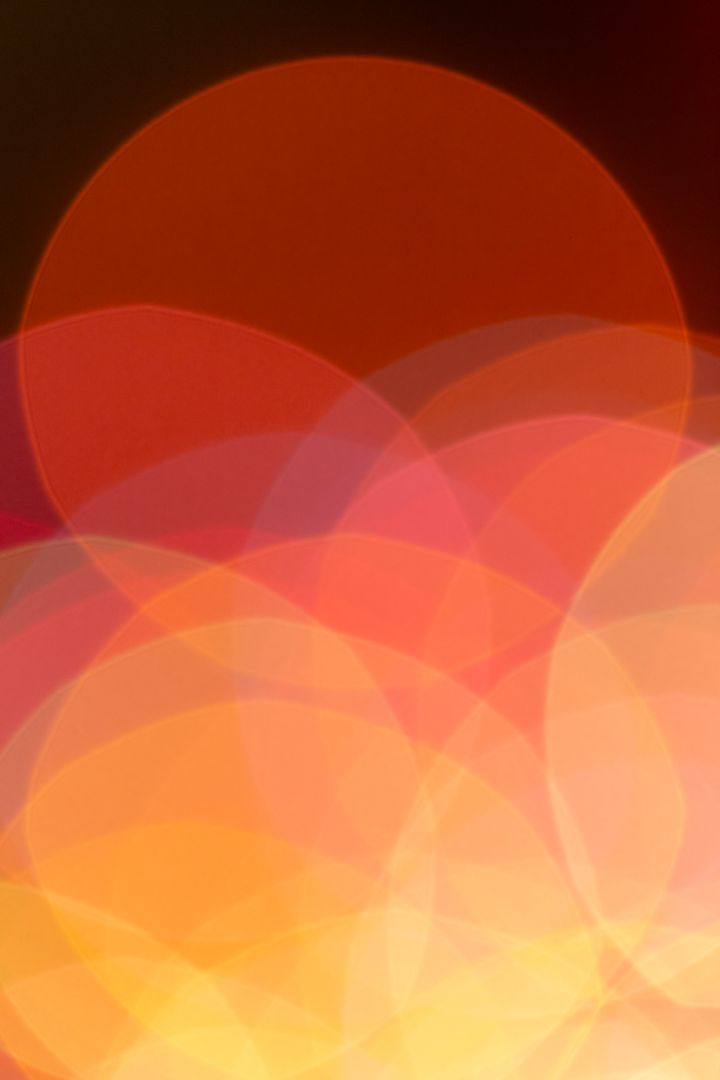 Warm Bokeh Circles Creating Festive Orange and Red Light Blur Background for Design